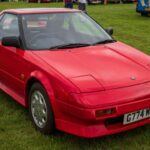 El Toyota MR2 es uno de esos coches que ha pasado a la historia como un modelo clave para los entusiastas de los deportivos. Este deportivo de motor central fue asequible y extremadamente divertido de conducir. Su estilo “low-budget Ferrari” lo convirtió en un éxito entre los fanáticos del automovilismo que buscaban un coche accesible pero con altas prestaciones. El MR2 fue muy querido por su reliabilidad y sus costes de mantenimiento bajos, características poco comunes en los deportivos de la época.