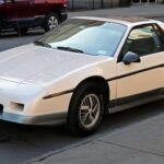 El Pontiac Fiero GT ha sido uno de los autos más subestimados de los 80. Con un motor V6 de 2.8 litros, el Fiero GT tiene una configuración de motor central que le da un gran equilibrio y manejo. A pesar de sus fallos iniciales, la versión de 1985 y posteriores resolvió muchos de los problemas, ofreciendo un rendimiento aceptable y un diseño único. Su precio se mantiene bajo, con algunos modelos en buen estado disponibles por 6.600 dólares. Si te gustan los autos con una personalidad peculiar y quieres algo que se destaque, el Fiero GT es una excelente opción.