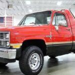 La Chevrolet K10 “Sno Chaser” de 1984 fue una camioneta especializada para la nieve, diseñada específicamente para enfrentar las condiciones invernales más extremas. Con tracción en las cuatro ruedas, neumáticos para nieve y suspensión resistente, la K10 estaba lista para dominar las carreteras heladas. Su motor V8 de 6.6L (400 pulgadas cúbicas) entregaba 190 caballos de fuerza, y su pintura roja brillante con franjas doradas la hacía aún más llamativa. Solo se fabricaron entre 150 y 300 unidades, convirtiéndola en una de las camionetas más raras para condiciones frías.
