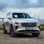 El Volvo XC90 2025 renueva su SUV insignia con un diseño minimalista y pantallas más grandes, manteniendo la esencia de seguridad sueca con calificación de cinco estrellas IIHS. Su motor híbrido suave de cuatro cilindros y 2.0 litros, con batería de 48 V, proporciona eficiencia y capacidad de conducción eléctrica limitada en modelos PHEV. Su interior combina madera y luz ambiental cálida, ofreciendo comodidad y sofisticación para tres filas de ocupantes. Con un precio base de $62,370, es una opción excelente para familias que buscan lujo, tecnología y eficiencia en un SUV híbrido suave.