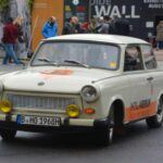El Trabant, producido en Alemania Oriental entre 1957 y 1989, es probablemente uno de los coches más reconocibles del siglo XX. Fabricado con un motor de dos tiempos y carrocería de plástico reciclado, era simple hasta lo extremo. Sin embargo, se convirtió en un símbolo de la vida tras el Telón de Acero y, tras la caída del Muro de Berlín, en un ícono cultural cargado de nostalgia.