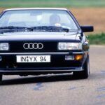 El pionero de la tracción integral

El Audi Quattro no es solo un coche, es un símbolo. Introducido en 1980, fue el primer modelo de Audi en incorporar la tracción quattro, un sistema de tracción integral que revolucionó los rallys. Su diseño innovador y su capacidad para dominar el terreno más difícil hicieron de este coche un referente de la marca.

El Audi Quattro no solo destacó en los rallys, sino que también fue un automóvil icónico en la carretera. Su producción continuó hasta 1991, y se le reconoce como el coche que cimentó la base de la marca Audi tal como la conocemos hoy, con una combinación de tecnología avanzada y un rendimiento espectacular.