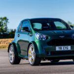 El Aston Martin Cygnet V8 es, sin duda, uno de los coches rebautizados más inusuales y sorprendentes de todos los tiempos. Originalmente un Toyota iQ, este compacto urbano fue transformado por Aston Martin para cumplir con las normativas de emisiones de la UE. Sin embargo, lo que realmente sorprendió fue la decisión de los ingenieros de equiparlo con un motor V8 de 4.7 litros, lo que lo convirtió en un modelo único en su especie. El Cygnet V8 pasó de ser un coche económico a una máquina que, aunque pequeña, era capaz de ofrecer una experiencia de conducción impresionante, digna del nombre Aston Martin.