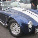 El Shelby Cobra 427 1966 es un auténtico monstruo de la carretera, con su chasis ligero y su motor V8 que garantizaba una aceleración brutal. Nacido de la visión de Carroll Shelby de combinar lo mejor de Inglaterra y América, este coche sigue siendo un referente de potencia y diseño en la historia de los convertibles.