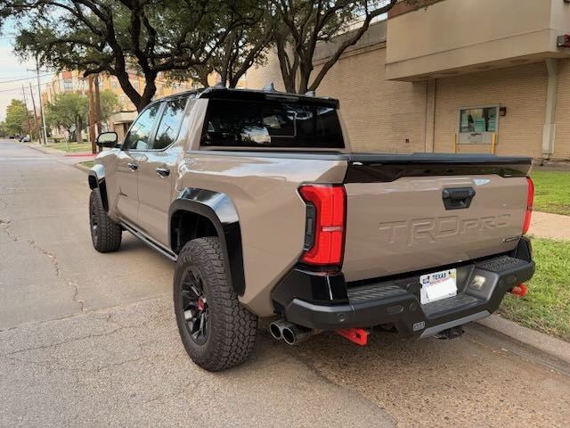 Trasera 3/4 de una Toyota Tacoma 2025 color arena