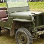 El Willys MB es posiblemente el Jeep más importante en la historia de la marca, ya que fue el prototipo de todos los vehículos todoterreno modernos. Producción durante la Segunda Guerra Mundial, el Willys MB fue un vehículo esencial para las fuerzas armadas de Estados Unidos. Su diseño simple pero robusto, con tracción a las cuatro ruedas, lo convirtió en el compañero perfecto para condiciones extremas. Aunque no se produjo para uso civil, fue clave para el nacimiento de la línea Jeep tal como la conocemos hoy. Con el contrato del Departamento de Guerra de EE. UU. para producir 16,000 unidades, el Willys MB sentó las bases del éxito de Jeep en el mercado de vehículos todoterreno.