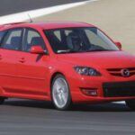 Si te gustan los hot hatches y buscas algo accesible, el MazdaSpeed3 es una opción fantástica. Equipado con un motor turboalimentado de 2.3 litros que produce 263 caballos de fuerza, este compacto es rápido, divertido y práctico.
Disponible con una caja manual de 6 velocidades, el MazdaSpeed3 ofrece una experiencia de conducción dinámica y emocionante. Los modelos más antiguos (2007-2009) son más crudos, mientras que los modelos más nuevos (2010-2013) refinaron el conjunto para ofrecer una mejor experiencia diaria. Su precio en el mercado de coches usados lo convierte en uno de los hatchbacks más rentables de su clase.
