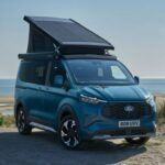 El Ford Nugget, conocido también como Pepita, es la versión camper del Ford Transit Custom que Ford diseñó en colaboración con Westfalia. Esta furgoneta cuenta con un techo elevable que ofrece un espacio extra para dormir y una capacidad de camping increíble. Con un diseño que permite convertir los asientos delanteros en una zona de descanso y una mesa que se puede instalar entre las filas de asientos, el Nugget es perfecto para viajes de aventura. Además, la versión de largo alcance viene equipada con una cocina y armarios en el área de carga, lo que lo convierte en un vehículo ideal para acampadas. Con un sistema híbrido enchufable que ofrece una batería de 11.8 kWh, el Nugget puede funcionar en modo totalmente eléctrico durante 30 millas o alimentar dispositivos fuera de la red.