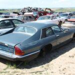 El Jaguar XJ-S fue uno de los coupés más elegantes de la década de 1980. Fabricado durante una larga producción que se extendió por 20 años, el XJ-S fue vendido en más de 84,000 unidades en todo el mundo. El modelo que encontramos en el desguace Martin Supply, en Colorado, es un XJ-S HE de 1983, uno de los 2705 vendidos en ese año en EE. UU. Este coche destaca por su carrocería sin óxido y la calidad que se conserva en su interior, a pesar de los daños visibles, como la falta de la insignia 'XJ-S'. El XJ-S es un verdadero clásico británico y, aunque es más raro de encontrar, sigue siendo un ejemplo de lujo y diseño en su mejor momento.