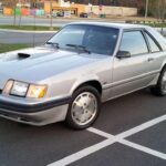 El Mustang SVO rompió con la tradición del V8 apostando por un motor turbo de cuatro cilindros y un enfoque técnico más refinado. Su producción limitada y sus soluciones aerodinámicas poco convencionales lo han convertido en una rareza muy apreciada. Paradójicamente, hoy alcanza precios superiores a muchos Mustang V8 de su época.