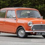 El Morris Mini Cooper de 1961 fue el precursor de todos los compactos deportivos modernos. John Cooper, genio detrás de los monoplazas de Fórmula 1 de motor central, vio en el Mini una base perfecta para la competición. Gracias a un árbol de levas más agresivo, doble carburación SU y válvulas de mayor tamaño, el pequeño motor A-Series de 998 cc ofrecía prestaciones inéditas para un coche urbano. Su éxito en competición amplió su atractivo y lo convirtió en un icono instantáneo.