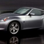 El Nissan 370Z puede parecer discreto en fotos, casi genérico, pero en directo transmite una confianza silenciosa. El capó largo, los voladizos cortos y la línea de techo baja le dan un aire de músculo moderno, heredero directo del ADN Datsun. Con el alerón adecuado, especialmente en especificación NISMO, su presencia se afila y gana un toque casi europeo. Bajo la luz natural, los detalles cobran vida y el conjunto resulta mucho más atractivo de lo esperado.