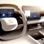 Regresan los controles dedicados del clima con una franja física bajo la pantalla central para temperatura y balizas. Además, un mando giratorio para volumen y pistas se sitúa entre el portavasos y la bandeja del móvil, al alcance de todos.