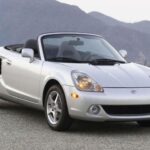 El MR2 Spyder representó la apuesta de Toyota por la ligereza extrema y la pureza de conducción. Con apenas 1.000 kg de peso, motor central y tracción trasera, ofrecía una agilidad extraordinaria. Su problema fue una estética discutible y un espacio de carga casi inexistente, lo que limitó su atractivo comercial pese a ser uno de los deportivos más divertidos de su categoría.