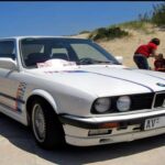 El E30 325i mantiene un precio accesible frente al M3, pero ofrece un equilibrio y una conducción muy similar. Motor seis cilindros en línea de 2.5L y tracción trasera, con electrónica sencilla que reduce costes de mantenimiento. Los compradores valoran interiores originales y coches sin óxido. Un ejemplar cuidado suele rondar los 17.100 dólares.