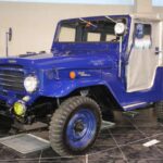 El Toyota BJ, precursor del Land Cruiser, copiaba el diseño del Jeep militar pero con un motor más potente y un chasis robusto. Su tracción total simple y su capacidad todoterreno lo convirtieron en un vehículo confiable para el ejército y la policía japonesa, capaz de escalar el Monte Fuji.