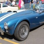 El Mark II surgió con mejoras de manejo, incluyendo dirección rack-and-pinion y chasis optimizado. Equipado con el motor 289 ci, ofrecía 271 hp y un peso de 2,205 libras. Entre 1963 y 1965 se produjeron 526 unidades, consolidando al Cobra como un coche ligero y potente, capaz de enfrentarse a Corvettes y Ferraris de la época.