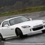 Para celebrar su 50 aniversario, Honda lanzó el S2000, un roadster puro y radical. Su motor 2.0 atmosférico con tecnología VTEC entregaba 243 CV y giraba a regímenes altísimos, convirtiéndose en el más potente por litro en su lanzamiento en 1999. Más de 100.000 unidades vendidas consolidaron su estatus como uno de los deportivos japoneses más admirados de todos los tiempos.