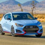 El Hyundai Veloster N es un coche que se entiende mejor en persona. Sus proporciones, algo peculiares en imágenes, funcionan cuando se aprecia su postura baja y compacta. El kit aerodinámico, el alerón y las salidas de escape centrales transmiten claramente su intención deportiva. No busca ser fino ni discreto; quiere ser divertido, y eso se percibe claramente al verlo de cerca.