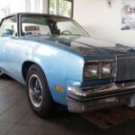 El Oldsmobile Cutlass Supreme fue una figura destacada en las carreteras de Estados Unidos durante los años 70 y 80. Ganador del Motor Trend’s 1976 “Car of the Year”, el Cutlass Supreme representaba comodidad y estatus. Su diseño refinado y sus características de confort lo convirtieron en un favorito tanto para familias como para flotas de policía, lo que aseguró su presencia en las calles durante varias décadas. Aunque hoy está en gran parte olvidado, su legado sigue siendo recordado por aquellos que vivieron esa época dorada de la automoción.