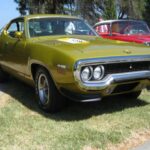 El Plymouth Road Runner Hemi 1971 permitía ordenar el motor 426 de 425 hp en un paquete de tamaño medio. Solo unas 55 unidades Hemi fueron producidas, reflejando la retirada del mercado ante seguros elevados y regulaciones, convirtiéndose en la última expresión de su reputación de alto rendimiento.