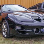 En los años 90, el espíritu muscle sobrevivía apenas. El Firebird de cuarta generación, producido entre 1993 y 2002, escondía más potencial del que aparentaba.

En las versiones Trans Am, el V8 LT1 de 5.7 litros entregaba entre 275 y 310 hp. Con caja manual y techo T-top, estos Firebird finales hoy son subestimados, pero podrían convertirse en futuros clásicos.