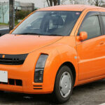 El Toyota WiLL Cypha fue uno de los coches más futuristas de su época sin siquiera llevar el nombre Toyota en su carrocería. Lanzado en 2002, incorporaba el sistema “G-Book”, una plataforma de infoentretenimiento revolucionaria que ofrecía navegación, correo electrónico, noticias, clima e incluso recomendaciones personalizadas. Además, introdujo un sistema de leasing basado en el uso por kilómetro, algo extremadamente adelantado a su tiempo.