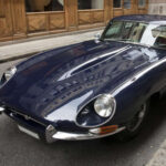 El Jaguar E-Type fue descrito por Enzo Ferrari como “el coche más hermoso jamás creado”. Su largo capó, su silueta fluida y sus faros carenados lo convierten en una obra de arte sobre ruedas que sigue siendo admirada desde 1961.