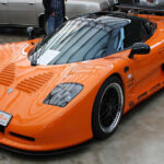 El Mosler MT900 apostó por una filosofía radical de ligereza extrema. Su estructura de fibra de carbono y su motor de origen Corvette lo convertían en un coche extremadamente rápido y eficiente en pista. Sin embargo, su producción artesanal limitó su difusión.