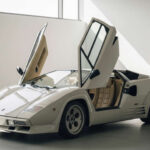 El Lamborghini Countach redefinió el concepto de superdeportivo con su diseño radical y sus puertas de tijera. Pero más allá de su estética, era un coche difícil de conducir, con un motor V12 explosivo y una ergonomía complicada. Era tan espectacular como intimidante.