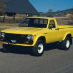 La Toyota Hilux fue una revolución al incorporar tracción total en un pick-up compacto. Su fama de indestructible comenzó aquí, convirtiéndose en una herramienta fiable tanto en carretera como fuera de ella.