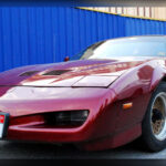 El Pontiac Firebird Trans Am se convirtió en el símbolo definitivo de los muscle cars de finales de los años 70. Aunque las cifras de potencia ya no eran tan salvajes como en la década anterior, mantenía toda la agresividad visual gracias a sus enormes gráficos, capó shaker y carrocería ensanchada. Su presencia intimidante y enorme popularidad en la cultura pop lo transformaron en una auténtica leyenda estadounidense, especialmente entre quienes se negaban a aceptar el final de la era dorada de los V8 americanos.