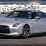 Cuando llegó al mercado en 2008, el Nissan GT-R R35 sorprendió a la industria por ofrecer prestaciones de nivel Ferrari a un precio considerablemente inferior. Su motor V6 biturbo ensamblado a mano desarrollaba 473 caballos y permitía acelerar de 0 a 100 km/h en apenas 3,6 segundos. Aunque su diseño era menos llamativo que el de otros exóticos europeos, sus capacidades dinámicas lo convirtieron rápidamente en una referencia mundial y en uno de los modelos más admirados por los entusiastas.
