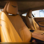 El interior del DB11 está revestido con cuero de altísima calidad procedente de Bridge of Weir, proveedor histórico escocés de materiales premium. Salpicadero, asientos, paneles, consola e incluso techo reciben acabados en cuero y costuras manuales que elevan la sensación de lujo a otro nivel.
