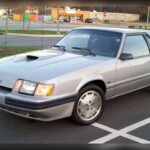Lejos de apostar por un gran V8, el Ford Mustang SVO optó por una fórmula innovadora basada en un motor turboalimentado de cuatro cilindros. Con 200 CV y una puesta a punto desarrollada por la división Special Vehicle Operations, ofrecía un comportamiento dinámico que sorprendía incluso frente a deportivos europeos mucho más caros. Fue una propuesta adelantada a su tiempo.