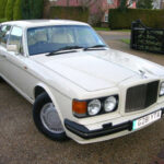 El Bentley Turbo R demostró que una enorme berlina de lujo también podía ser rápida y emocionante de conducir. Bajo su elegante carrocería escondía un gigantesco V8 turboalimentado de 6.8 litros capaz de entregar enormes cifras de par motor y una aceleración sorprendente para un coche de semejante tamaño. Bentley además mejoró considerablemente la suspensión y el comportamiento dinámico respecto a modelos anteriores, creando una experiencia mucho más deportiva sin perder el refinamiento artesanal típico de la marca británica.