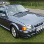 El Ford Escort RS Turbo se convirtió rápidamente en uno de los compactos deportivos más deseados de toda Europa durante los años 80. Basado en el Escort XR3i, utilizaba un turbo Garrett T3 para generar unos 132 caballos que, en un coche tan ligero, ofrecían sensaciones salvajes y una conducción extremadamente divertida. Su agresivo kit aerodinámico, las llantas específicas y el enorme alerón trasero definieron perfectamente la estética radical de la década. Hoy sigue siendo uno de los hot hatch más icónicos y cotizados entre los fanáticos de los deportivos clásicos.
