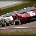 El Ford GT recuperó el espíritu del legendario GT40 con una interpretación moderna que conquistó a la crítica especializada. Equipado con un motor V8 de 5,4 litros sobrealimentado que entregaba 550 CV, ofrecía una velocidad máxima superior a los 330 km/h. Su diseño inspirado en el modelo vencedor de Le Mans y sus impresionantes prestaciones lo transformaron rápidamente en un icono contemporáneo.El Ford GT recuperó el espíritu del legendario GT40 con una interpretación moderna que conquistó a la crítica especializada. Equipado con un motor V8 de 5,4 litros sobrealimentado que entregaba 550 CV, ofrecía una velocidad máxima superior a los 330 km/h. Su diseño inspirado en el modelo vencedor de Le Mans y sus impresionantes prestaciones lo transformaron rápidamente en un icono contemporáneo.