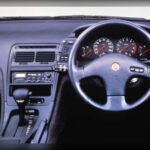 El interior del 300ZX también destacó por soluciones avanzadas como el climatizador automático digital, configurable mediante pantalla LCD. En los años 90, esta tecnología era vista como un gran lujo y demostraba cómo Nissan había aprendido a integrar innovación útil sin caer en excesos tecnológicos innecesarios.