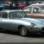 Presentado en 1961, el Jaguar E-Type redefinió la imagen del deportivo moderno. Su largo capó, sus líneas fluidas y sus proporciones perfectamente equilibradas transmitían sensación de velocidad incluso estando detenido. Considerado por muchos como uno de los automóviles más bellos jamás fabricados, demostró que el diseño y la ingeniería podían convivir en perfecta armonía, convirtiéndose en una referencia para generaciones de deportivos.