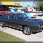 El Pontiac GTO de 1968 es considerado por muchos historiadores como el primer muscle car auténtico. Su motor V8 de 400 pulgadas cúbicas entregaba hasta 360 caballos de potencia, proporcionando una aceleración contundente y una respuesta inmediata que lo convirtieron en una referencia absoluta dentro del mercado estadounidense.